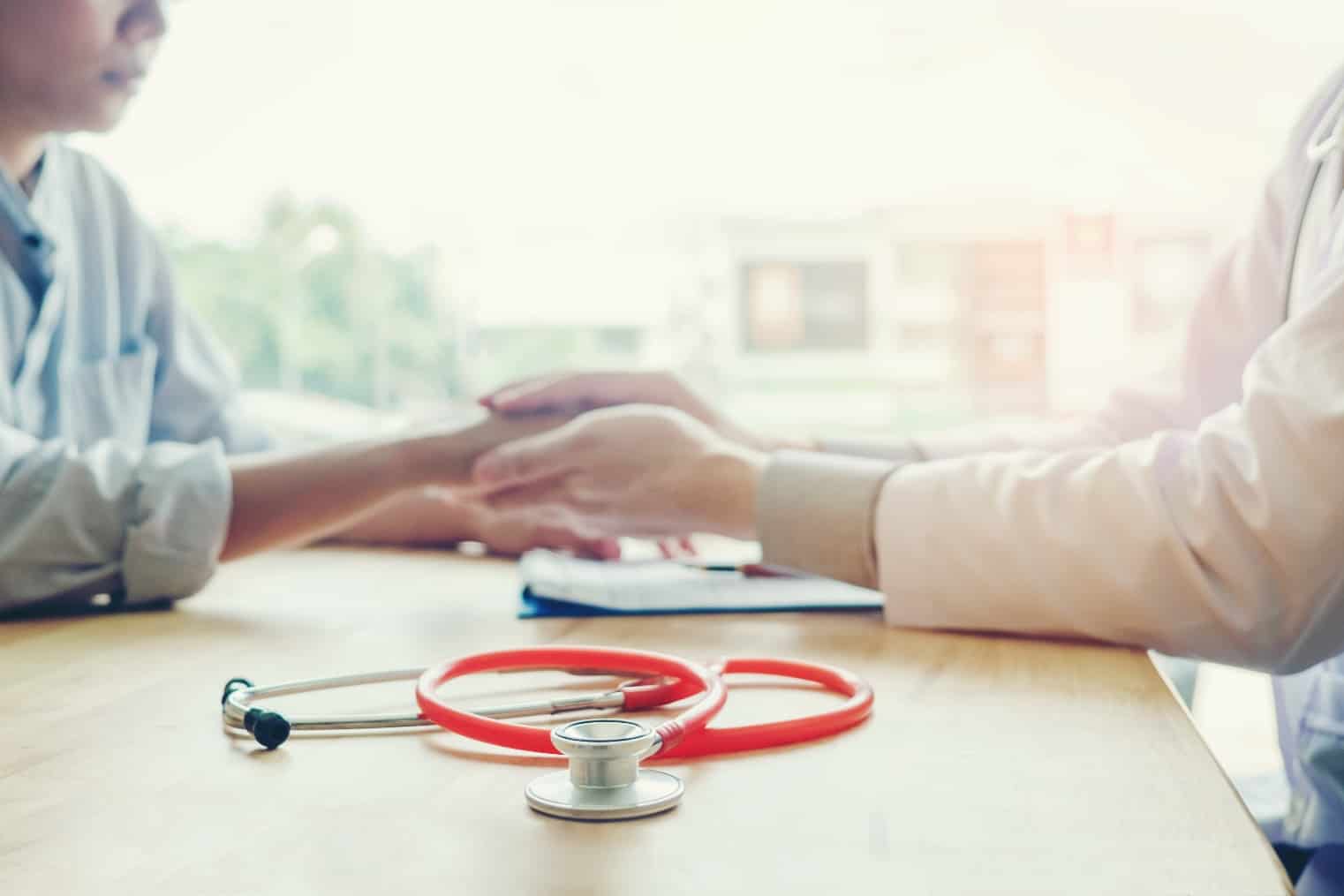 Doctor holding hand of patient